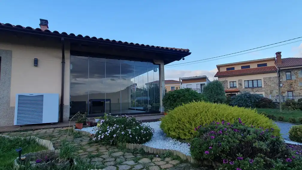 a building with a glass wall and a garden