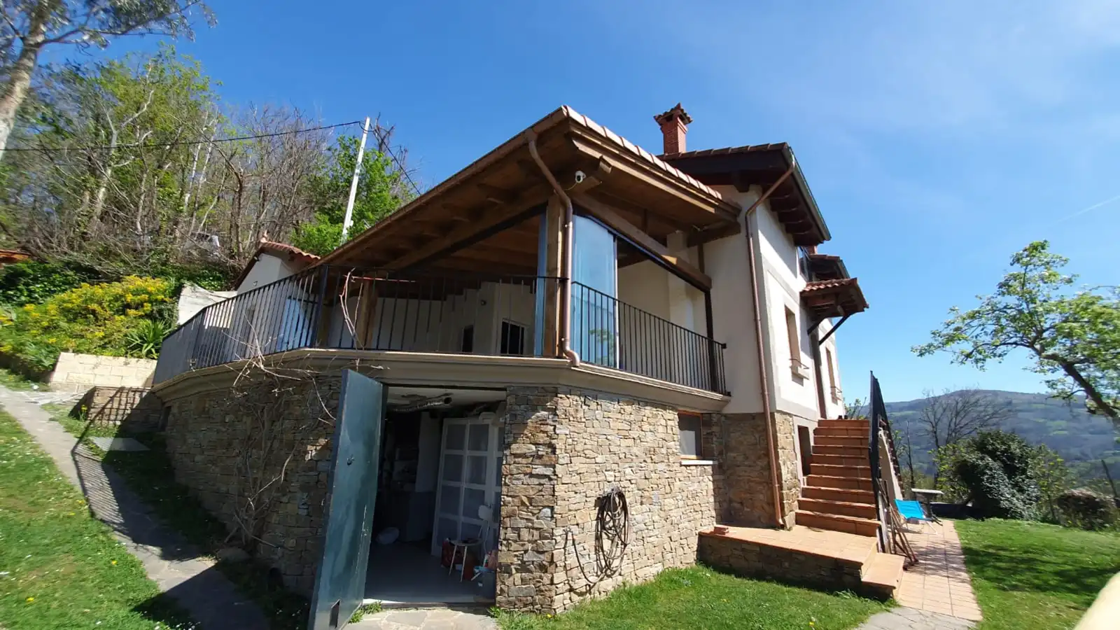 Cerramiento de cristal panorámico en Sobrobio, Asturias, con vistas al valle y mobiliario de exterior