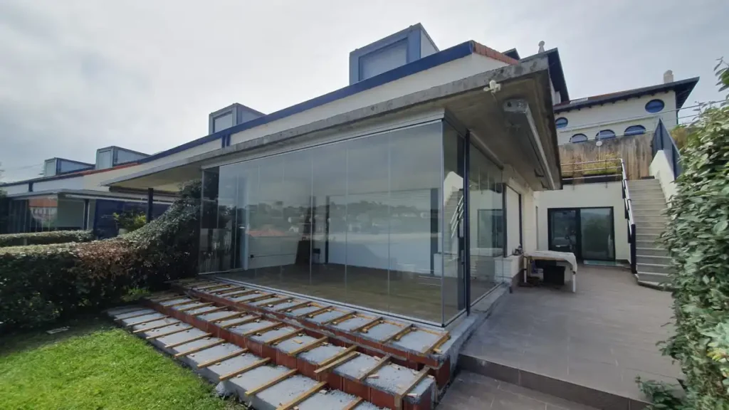 Cerramiento acristalado sin perfiles en terraza de chalet en Comillas, con vistas al mar Cantábrico, realizado por Cialca con cristales Lumon. h Cerramiento acristalado sin perfiles en terraza de chalet en Comillas, con vistas al mar Cantábrico, realizado por Cialca con cristales Lumon. h