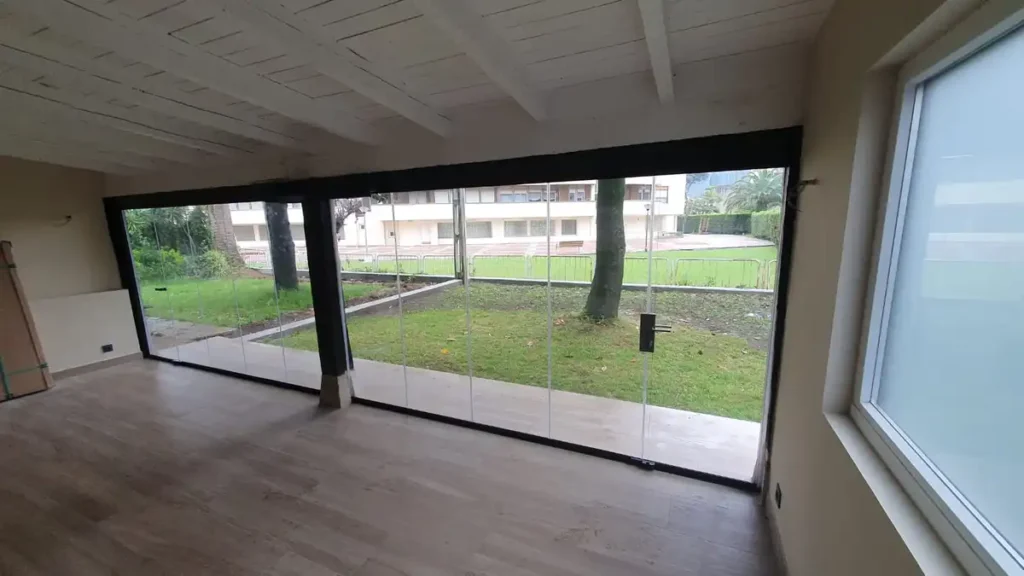 Cerramiento acristalado sin perfiles verticales en porche de vivienda en Castro Urdiales, realizado por Cialca con sistema Lumon.