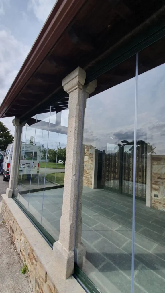 Instalación de cortinas de cristal Lumon en porche de piedra en Tapia de Casariego.