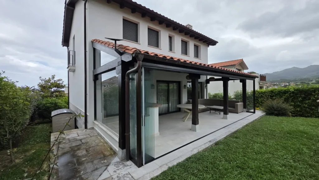 Cerramiento con cortinas de cristal Lumon en porche de madera de un chalet en La Isla, Colunga (Asturias), realizado por Cialca.2