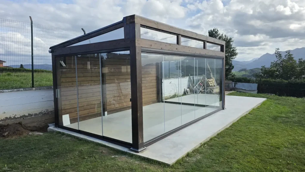• Cenador exento de madera con cerramiento completo de cortinas de cristal Lumon en un jardín de Santo Medero Asturias por Cialca
